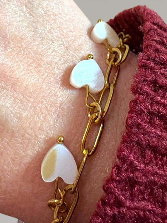 Bracelet chaîne dorée avec cinq cœurs en nacre porté au poignet, bijou symbolique amour de soi – Collection Pour Toi By Maryon