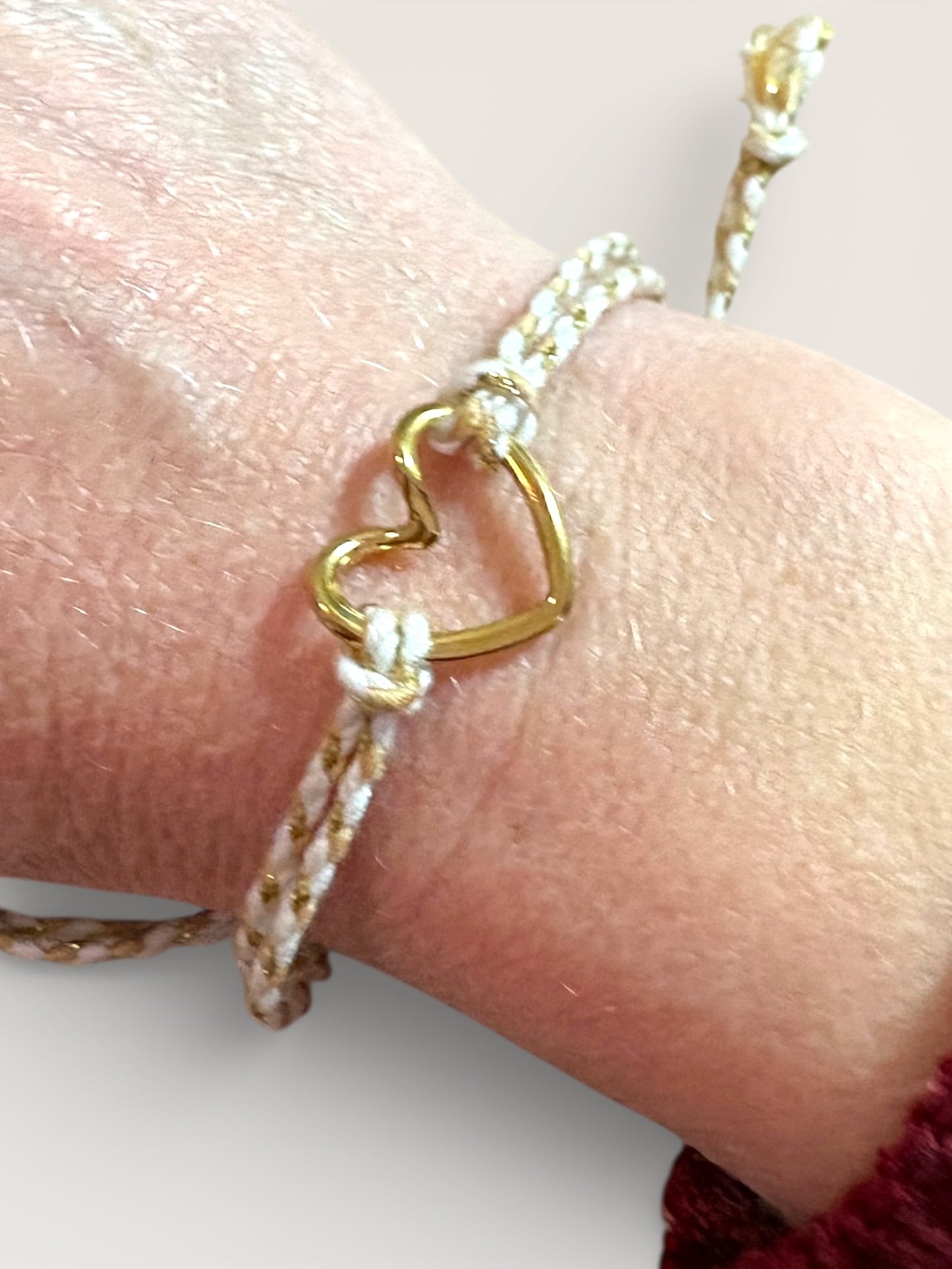 Bracelet cordon beige et doré avec cœur en acier inoxydable porté au poignet, bijou symbolique amour de soi – Collection Pour Toi By Maryon